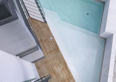 Vista cenital de la piscina en el acceso al edificio y vista parcial del detalle que resuelve el perímetro de las terrazas